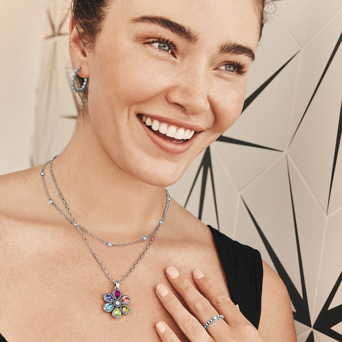 Model wearing a Brighton silver-plated flower pendant necklace with multicolored crystals and coordinating Brighton accessories