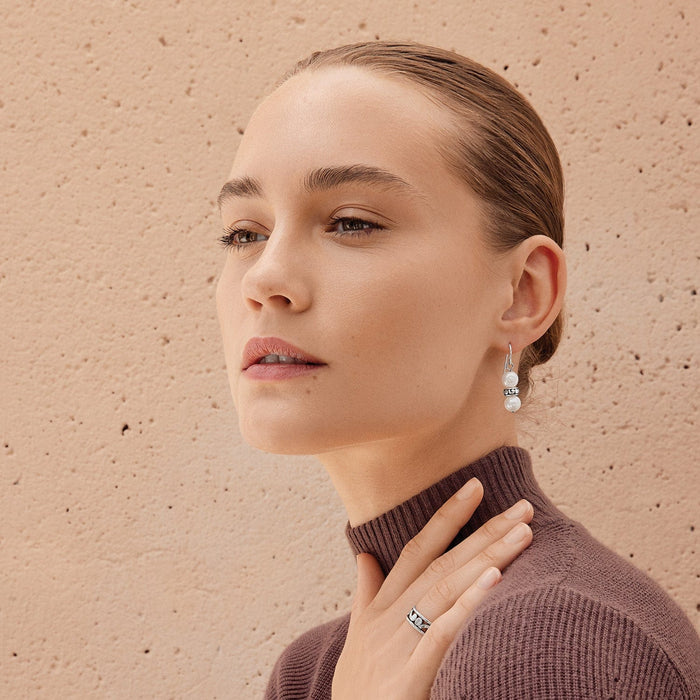 Model wearing Brighton silver-plated drop earrings with potato pearls paired with a coordinating silver-plated band ring