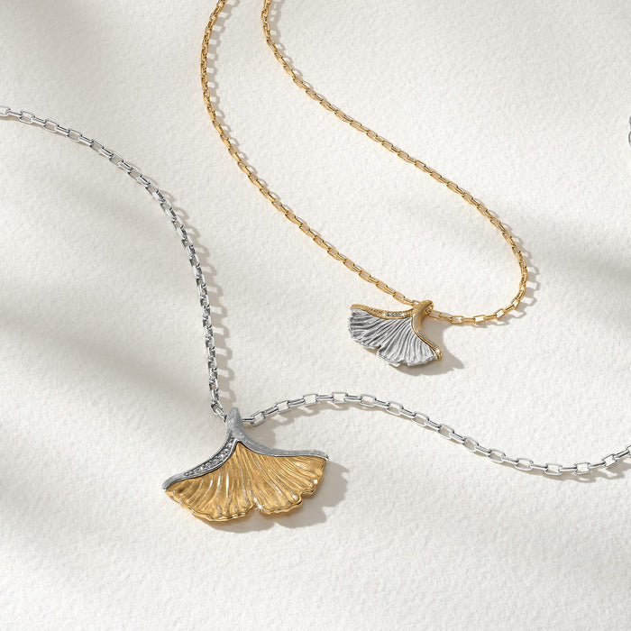 Brighton two-tone ginkgo leaf pendant necklaces styled with crystal accents and chain detailing on a neutral background