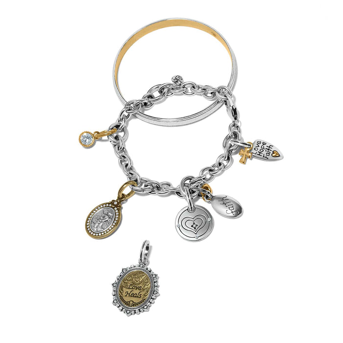 Brighton two-tone charm bracelet and bangle styled with an oval Love Heals crystal charm on white background