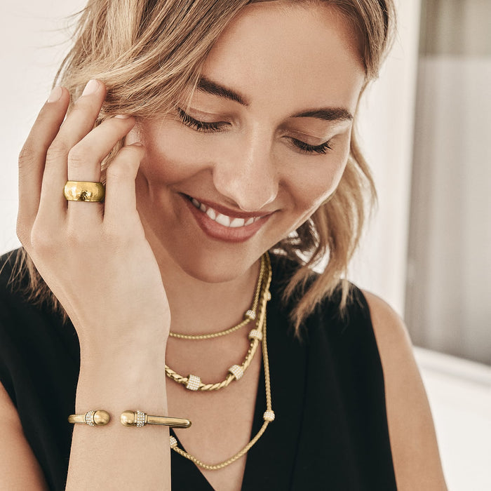 Model wearing a Brighton brushed gold plated ring with hammered band and coordinating Brighton accessories