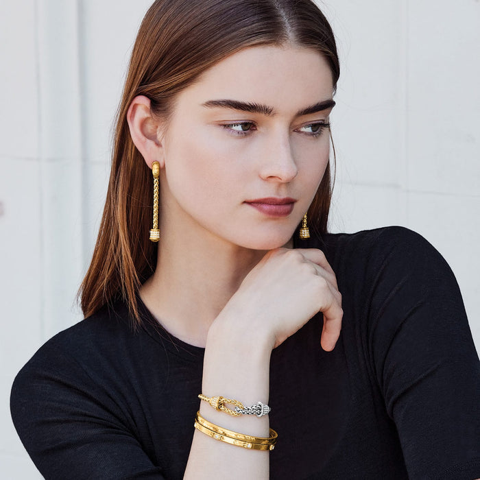 Model wearing Brighton gold drop earrings with crystal accents and coordinating Brighton two-tone bracelets with crystals