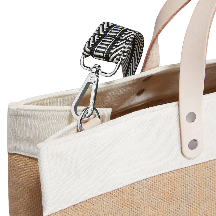 Close-up of Brighton tote silver-tone swivel clasp attaching black and white woven strap to canvas bag