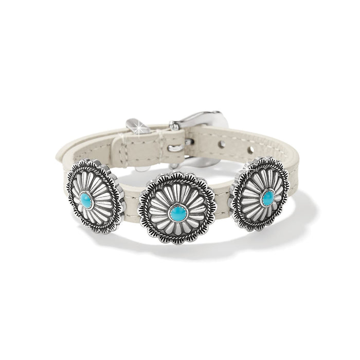 Brighton leather bracelet in cream with three silver-plated concho medallions and turquoise stone centers on a white background