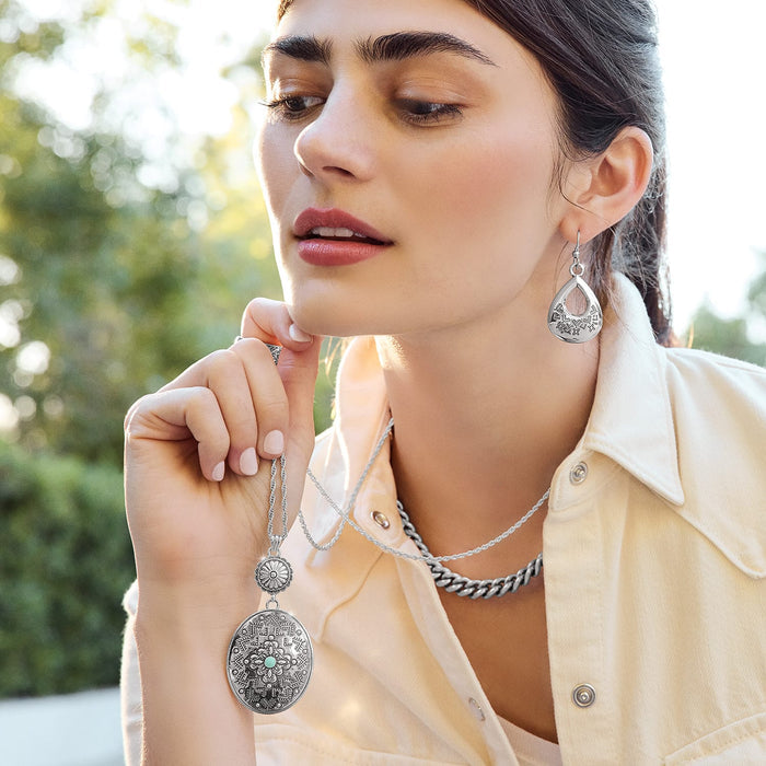 Model wearing Brighton silver-plated teardrop earrings with engraved detail and coordinating Brighton pendant and chain necklaces