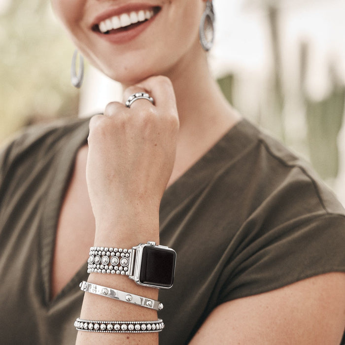 Model wearing a Brighton silver-plated beaded watch band with coordinating Brighton accessories including bangles and hoop earrings