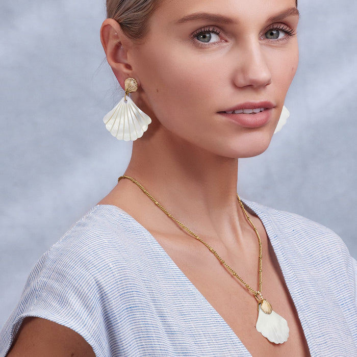 Model wearing Brighton gold-plated shell drop earrings paired with a matching gold-plated shell pendant necklace
