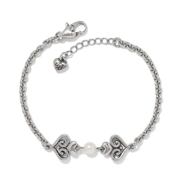 Brighton bracelet with silver-plated scroll heart accents and a glass pearl center on a white background