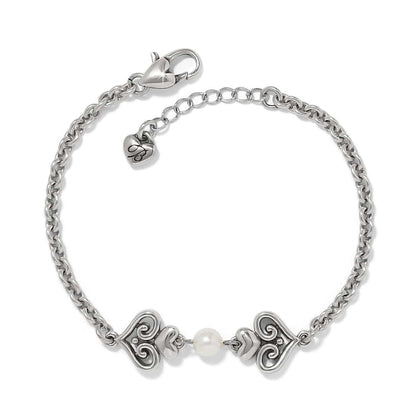 Brighton bracelet with silver-plated scroll heart accents and a glass pearl center on a white background
