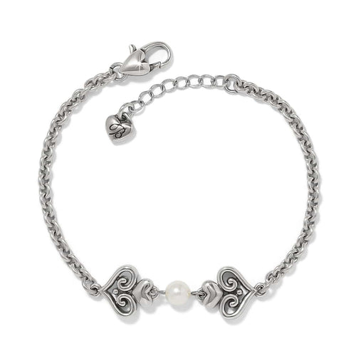 Brighton bracelet with silver-plated scroll heart accents and a glass pearl center on a white background