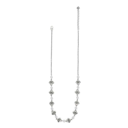Brighton silver-plated necklace with glass pearls and ornate scroll heart stations along the chain on a white background