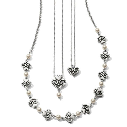 Brighton silver-plated necklaces with ornate scroll heart stations, glass pearls, and crystal-accented heart pendants on a white background