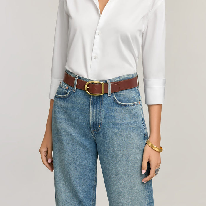 Model wearing a Brighton brown leather belt with gold-tone buckle, paired with jeans and a white shirt