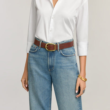 Model wearing a Brighton brown leather belt with gold-tone buckle, paired with jeans and a white shirt