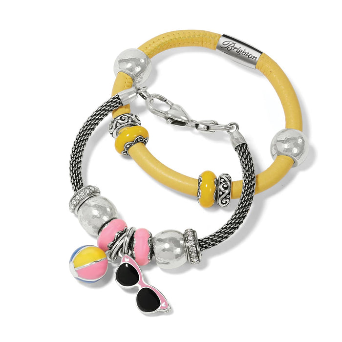 Brighton charm bracelets in yellow leather and silver-plated mesh with enamel beach ball and sunglasses charms on a white background