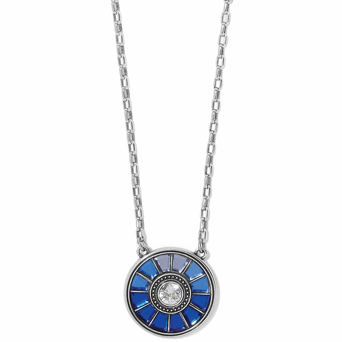 Brighton pendant necklace with silver-plated round disc, blue crystals, and central crystal accent on a white background