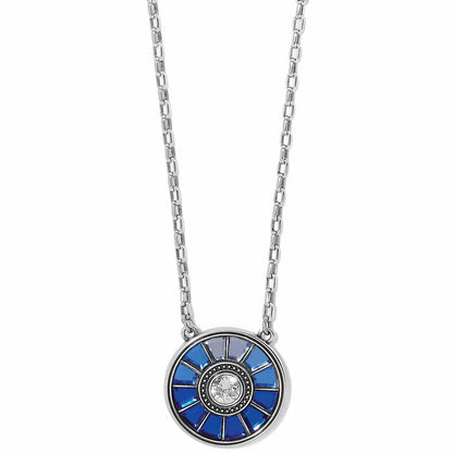 Brighton pendant necklace with silver-plated round disc, blue crystals, and central crystal accent on a white background