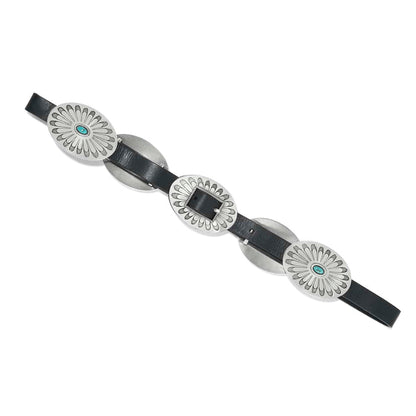 Brighton black leather belt with oversized oval silver-tone concho medallions and turquoise stone accents on a white background