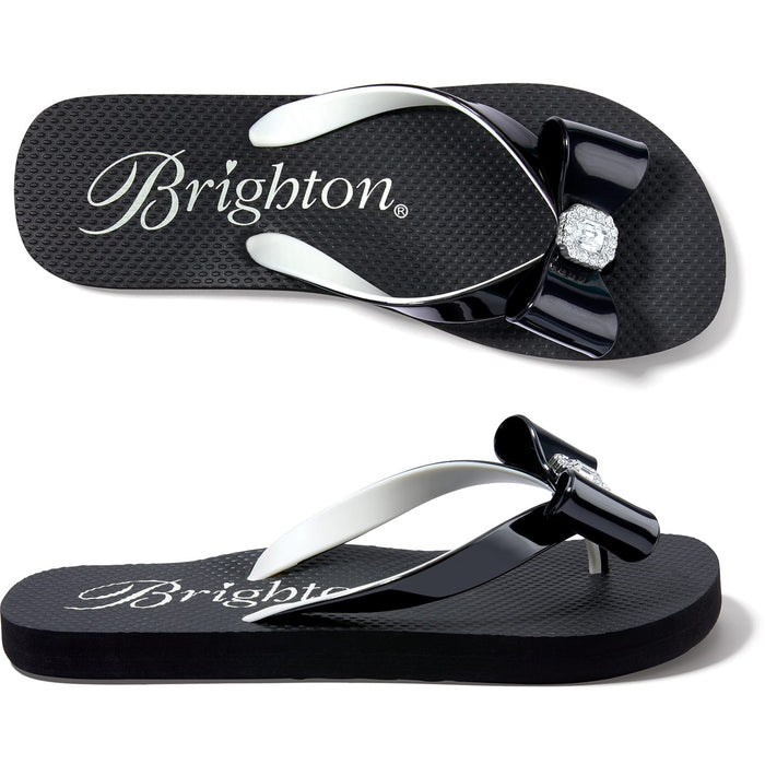 Brighton black rubber flip-flop sandals with glossy bow accent and crystal centerpiece, shown from two angles on a white background