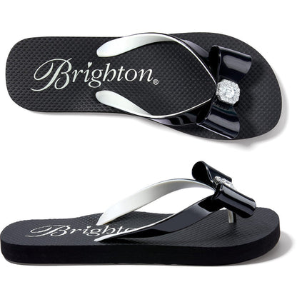 Brighton black rubber flip-flop sandals with glossy bow accent and crystal centerpiece, shown from two angles on a white background