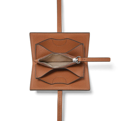 Brighton tan leather pouch shown open with silver-tone zipper, wrist strap, and long shoulder strap on a white background