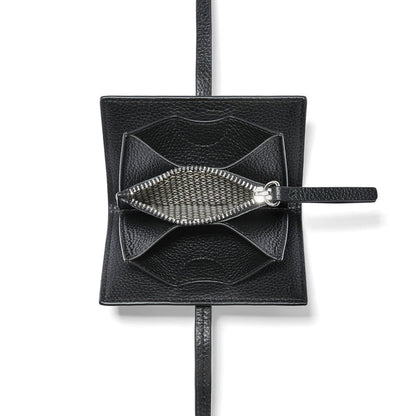 Close-up of Brighton black pebbled leather pouch shown open with silver-tone zipper and patterned interior lining