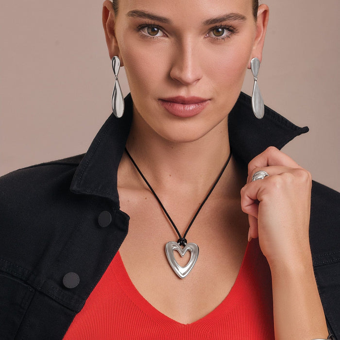 Model wearing a Brighton silver-plated heart pendant necklace on black cord with coordinating Brighton accessories
