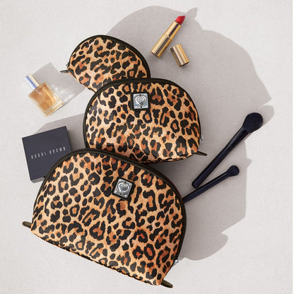 Brighton leopard print cosmetic pouches styled with lipstick and makeup brushes and other accessories on a neutral background