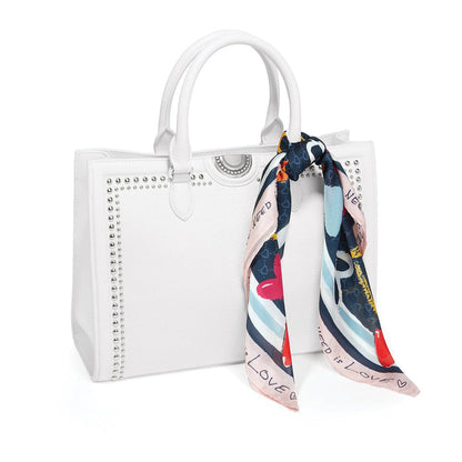 Brighton white leather handbag with silver-tone studs, dual handles, and printed scarf tied to side on a white background