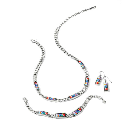 Brighton silver-plated necklace, bracelet, and earrings styled together with multicolor enamel mosaic panels on a white background
