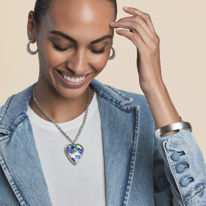 Model wearing a Brighton silver-plated heart pendant necklace with colorful geometric enamel design and coordinating Brighton accessories