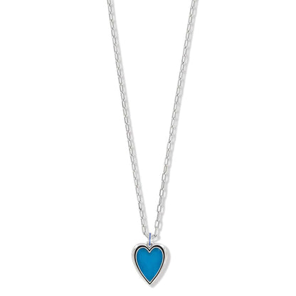 Brighton pendant necklace with blue enamel heart charm and silver-plated chain on a white background