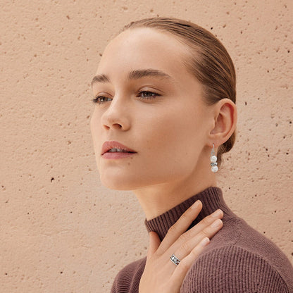 Model wearing Brighton silver-plated drop earrings with potato pearls paired with a coordinating silver-plated band ring