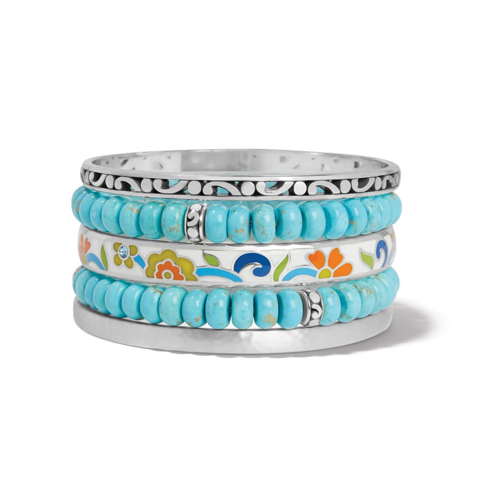 Brighton stacked bangle bracelets with turquoise beads, silver-plated scrollwork, and floral enamel design on a white background