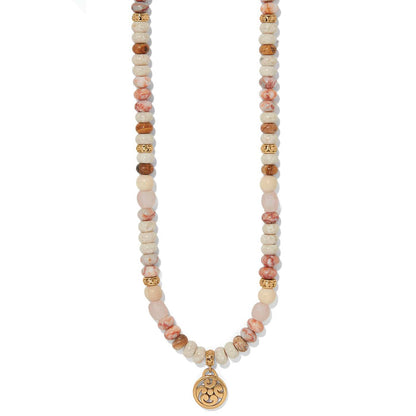 Brighton beaded necklace with web jasper, white howlite, picture jasper, rose glass, wood beads, and gold pendant on a white background