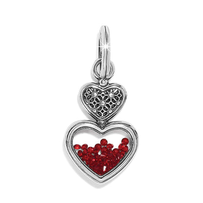 Brighton double heart charm with silver-plated filigree top and red crystals inside lower heart on a white background