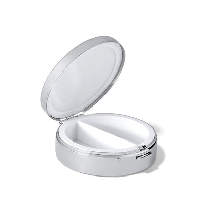 Brighton silver-tone pill box shown open with white divided interior compartments and side latch on a white background