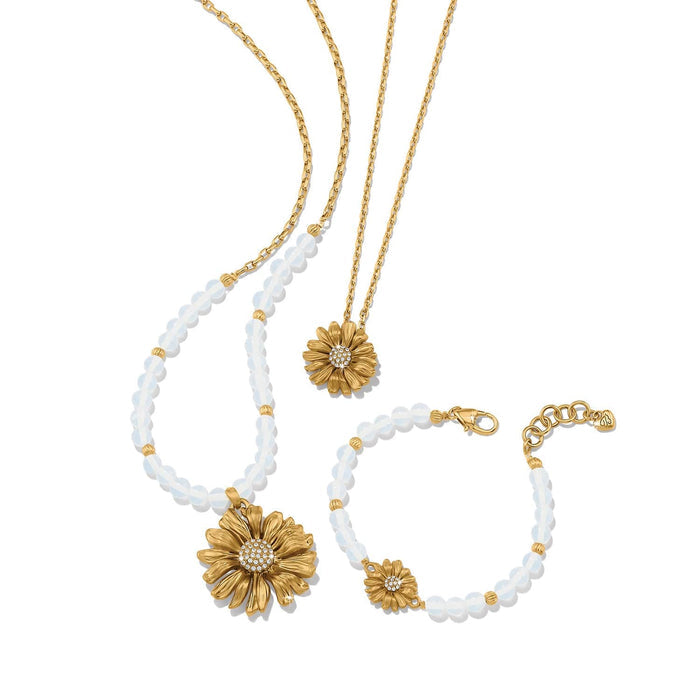 Brighton gold-plated daisy pendant necklaces and matching beaded bracelet with crystal centers and clear beads on a white background