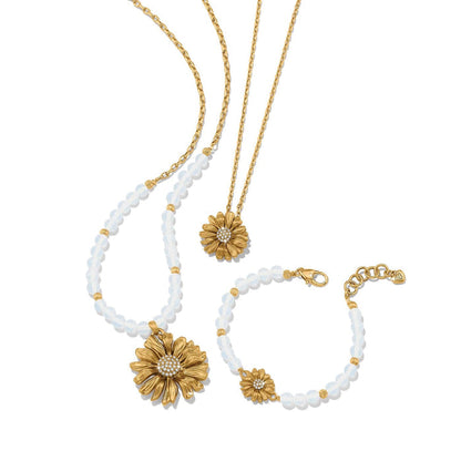 Brighton gold-plated daisy jewelry set styled with translucent beaded necklace and bracelet featuring crystal flower centers