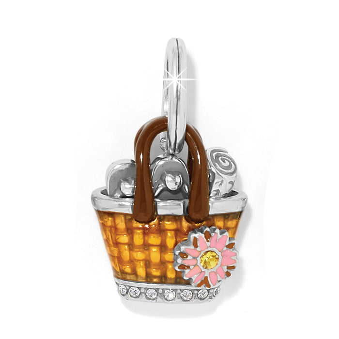 Brighton charm shaped like an orange enamel basket with pink flower, crystal accents, and silver-plated finish on a white background