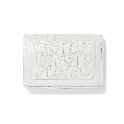 Brighton wallet in white leather with embossed LOVE lettering and heart motifs on a white background