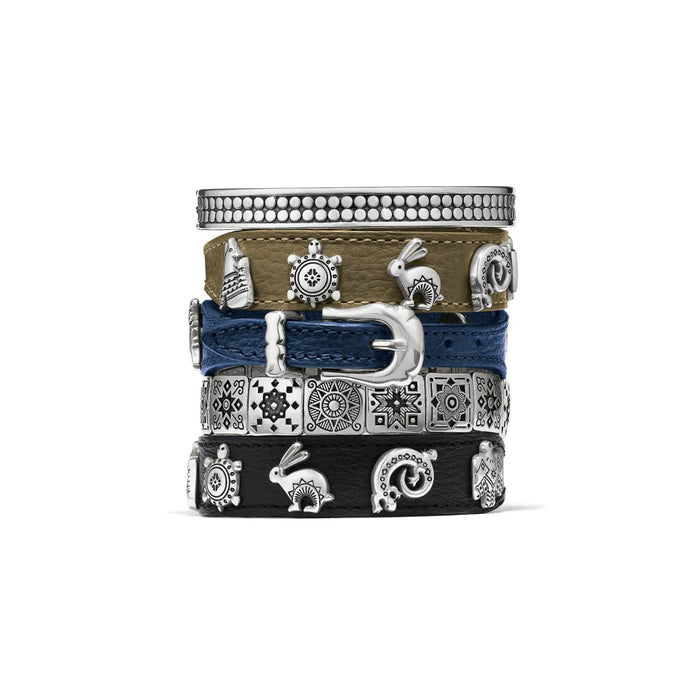 Brighton stacked bracelets in tan, blue, and black leather with silver-plated buckle, charms, and bangle on a white background