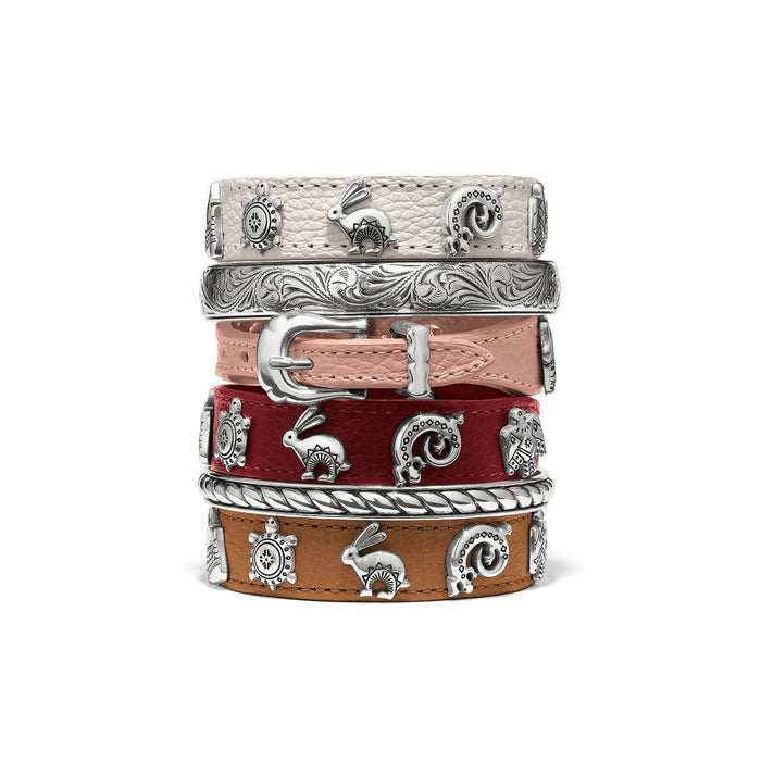 Brighton leather bracelets stacked in cream, pink, red, and tan with silver-plated animal charms and buckle on a white background