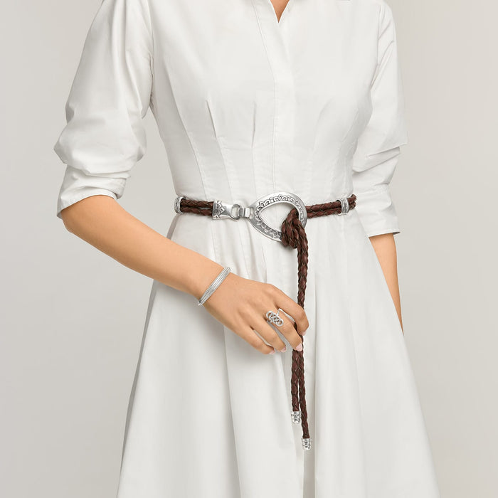 Model wearing a Brighton braided brown leather belt with ornate silver-tone oval buckle and hook closure
