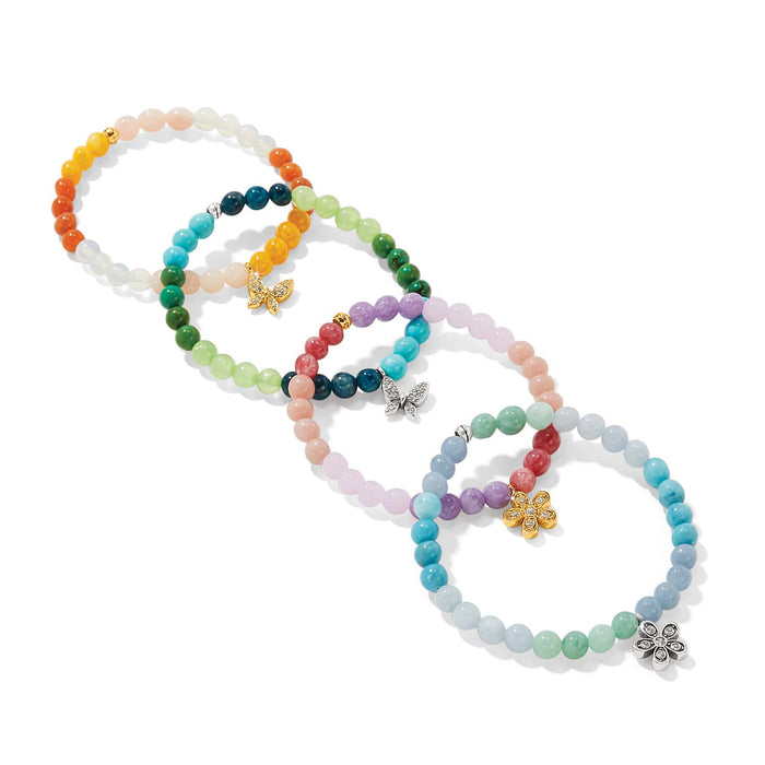 Brighton beaded stretch bracelets in assorted colors with crystal butterfly and flower charms in silver and gold on a white background