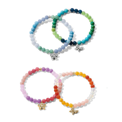Brighton beaded bracelets in blue, green, pink, and yellow tones with silver and gold flower and butterfly charms on a white background