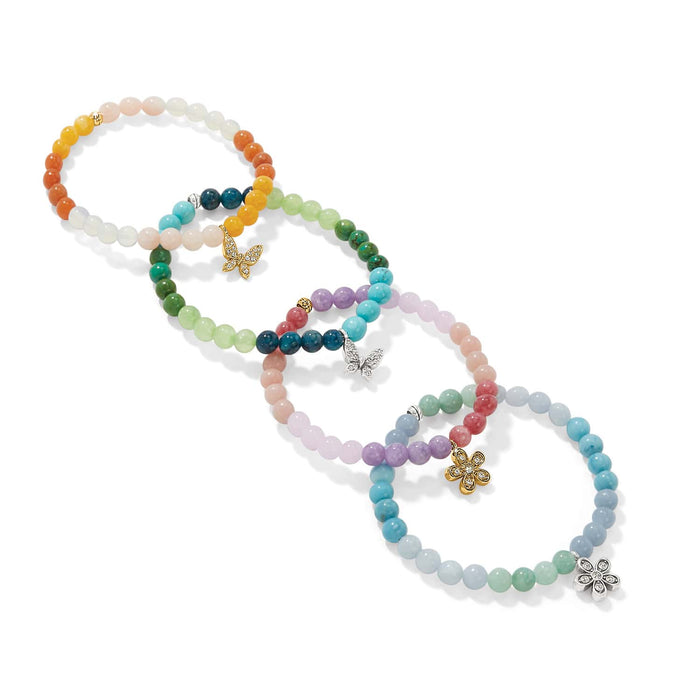 Brighton beaded bracelets in pastel colors with crystal butterfly and flower charms in silver and gold on a white background