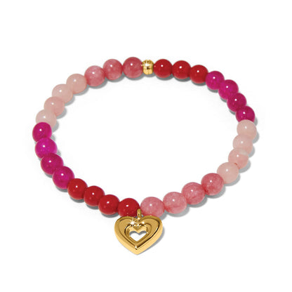 Brighton beaded bracelet with pink and red stone beads and gold-plated heart charm on a white background