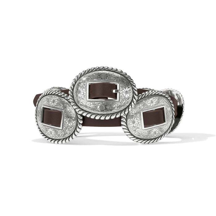 Brighton brown leather belt with oval silver-tone concho buckles featuring engraved floral and rope-edge detailing on a white background