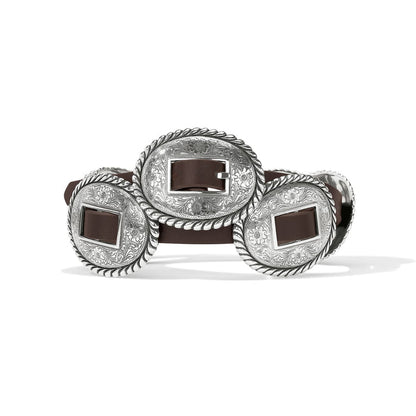 Brighton brown leather belt with oval silver-tone concho buckles featuring engraved floral and rope-edge detailing on a white background